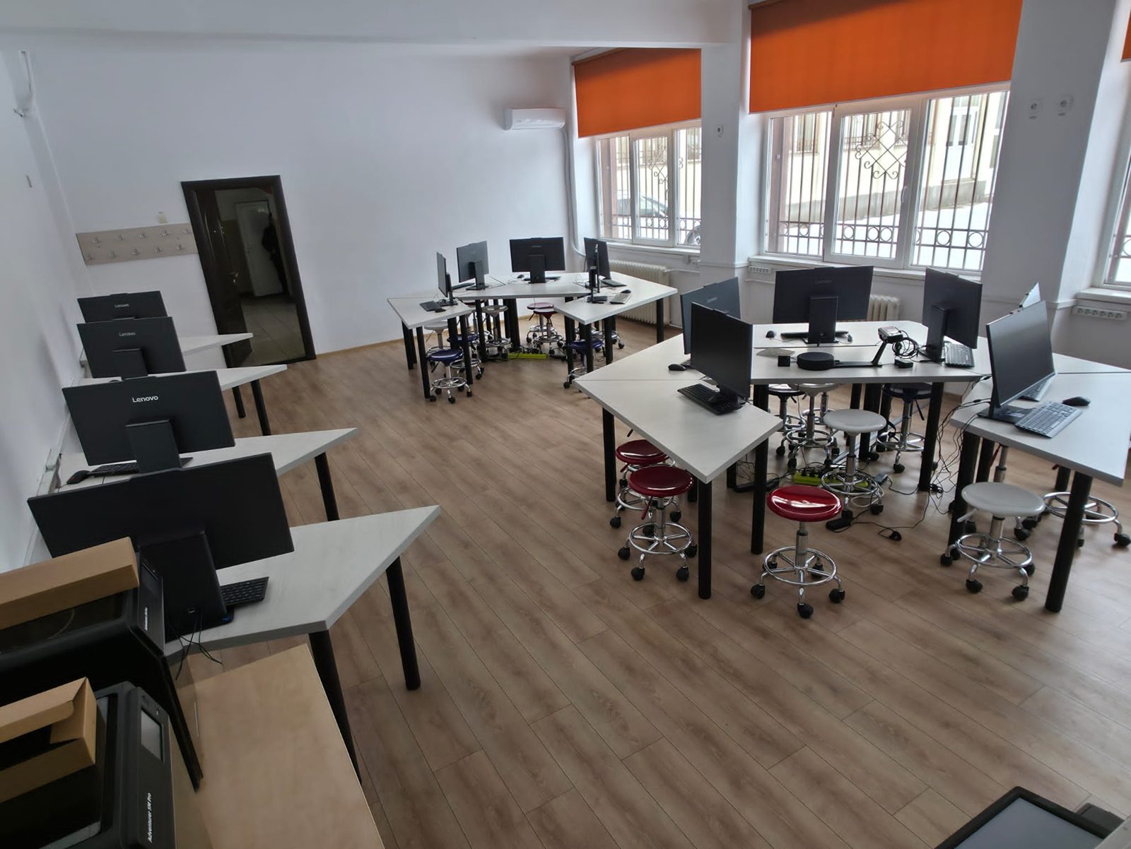 Laborator SmartLab văzut spre ferestre: mese modulare, monitoare și scaune ergonomice reglabile