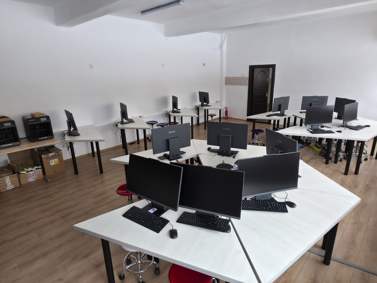 Laborator SmartLab: grupuri de mese cu câte patru monitoare, echipamente noi pe masa de lângă perete