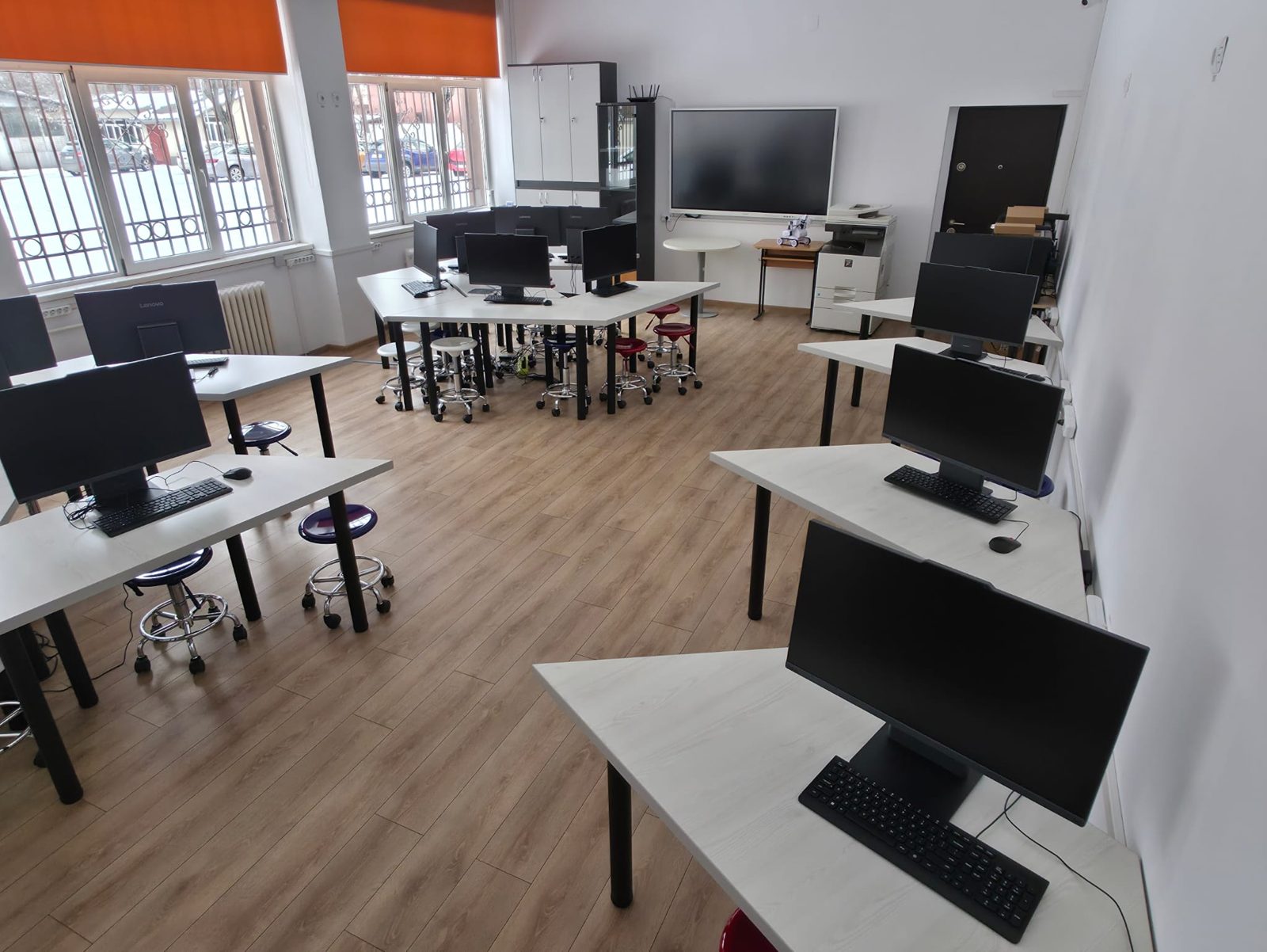 Vedere de ansamblu asupra laboratorului SmartLab, cu ecran interactiv pe peretele din fund și echipament multifuncțional